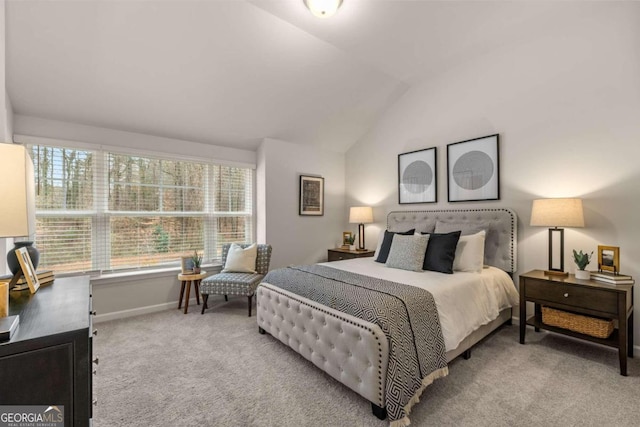 carpeted bedroom with vaulted ceiling and baseboards