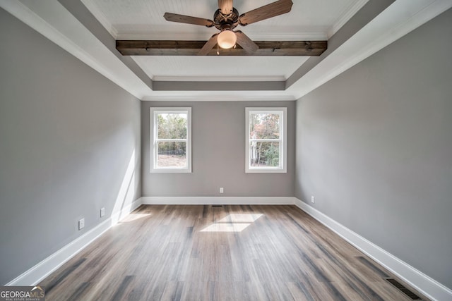 spare room with baseboards, wood finished floors, and ornamental molding