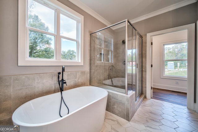 full bathroom with a freestanding bath, a shower stall, crown molding, and tile patterned flooring