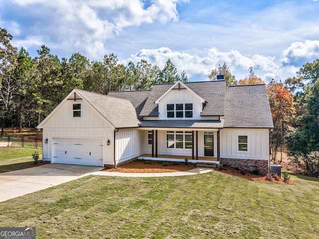 modern farmhouse style home featuring a front yard, driveway, a shingled roof, a garage, and board and batten siding