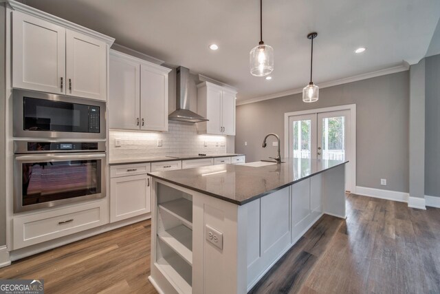 104 Bob White Dr, Calhoun, GA 30701 - kitchen with stainless steel oven, wall chimney range hood, built in microwave, ornamental molding, and white cabinetry