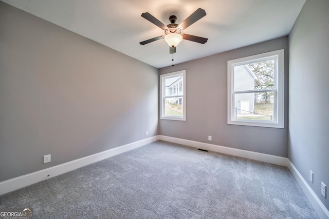 empty room featuring a ceiling fan, baseboards, and carpet floors