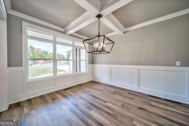 unfurnished dining area featuring visible vents, beam ceiling, wood finished floors, a notable chandelier, and coffered ceiling