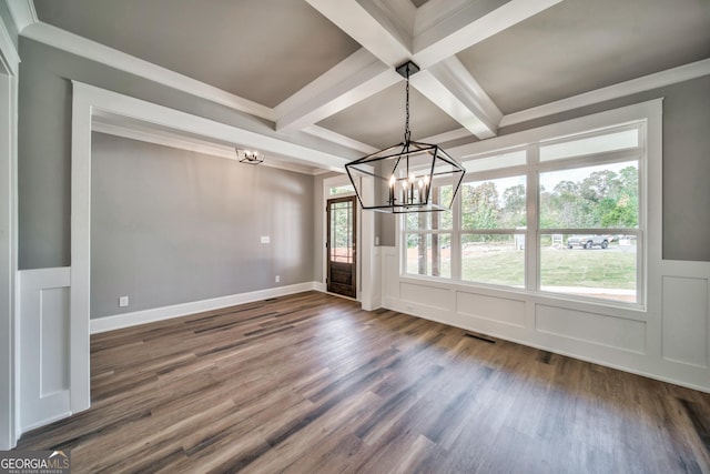 unfurnished dining area featuring a decorative wall, dark wood-type flooring, beam ceiling, a notable chandelier, and coffered ceiling