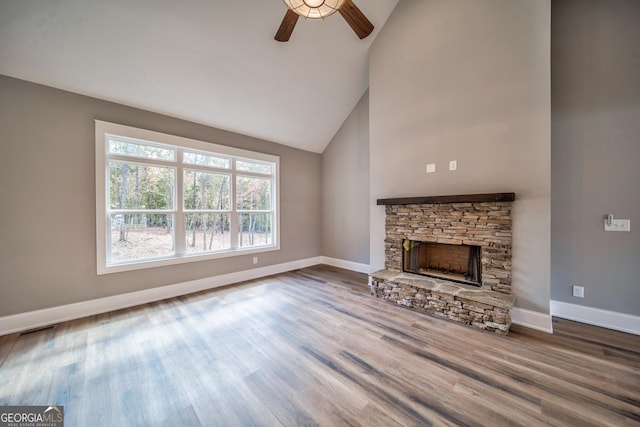 unfurnished living room with visible vents, wood finished floors, a fireplace, baseboards, and ceiling fan