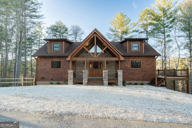 log cabin featuring a porch and faux log siding