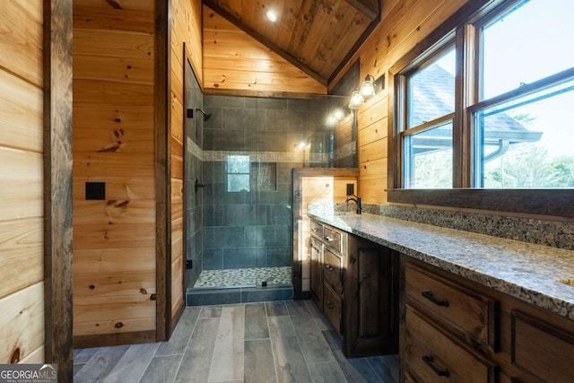 bathroom featuring lofted ceiling, wooden ceiling, wood walls, vanity, and a shower stall