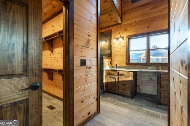 bathroom with wood walls and vanity