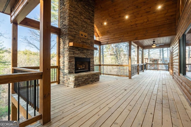 wooden terrace with an outdoor stone fireplace