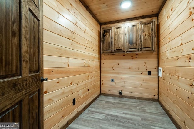 interior space featuring wooden ceiling, wooden walls, and wood finished floors