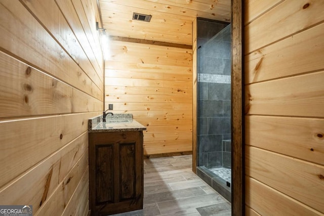 full bath with wooden ceiling, a shower stall, vanity, and wooden walls