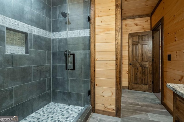 bathroom featuring a stall shower, wooden walls, and vanity