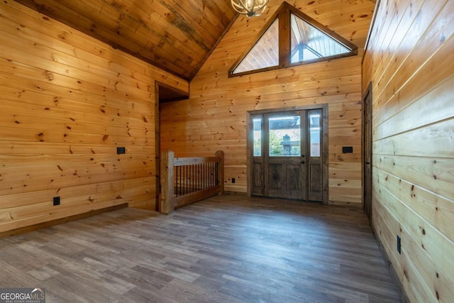 interior space featuring high vaulted ceiling, wooden ceiling, wood finished floors, and wooden walls