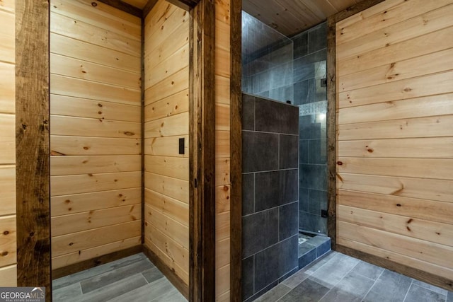 bathroom featuring a shower stall, wooden walls, and wood finished floors