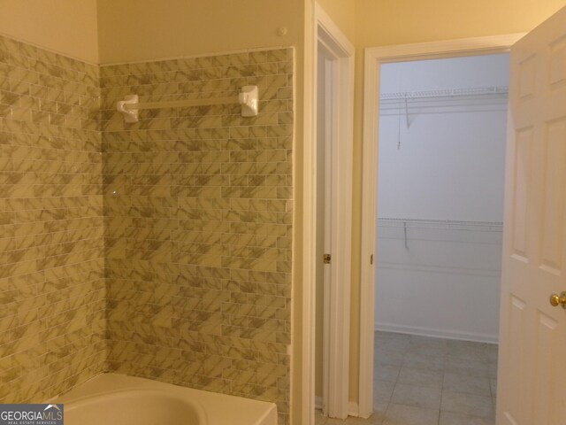 bathroom featuring tile patterned flooring and a walk in closet