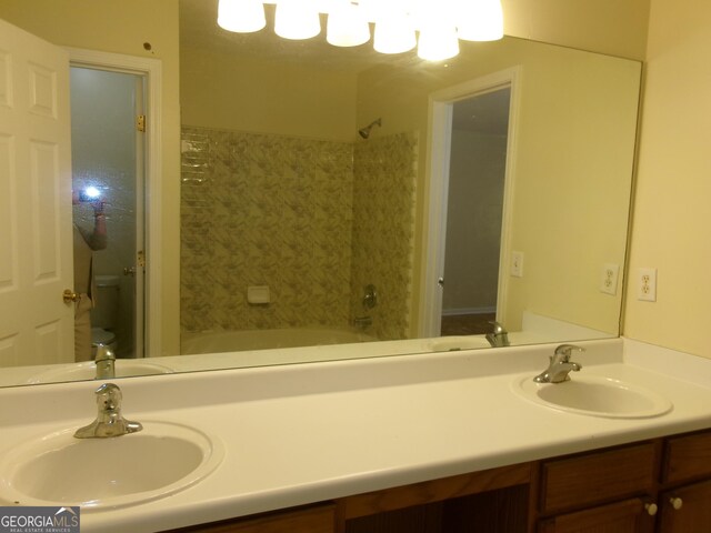 bathroom with  shower combination, vanity, and toilet