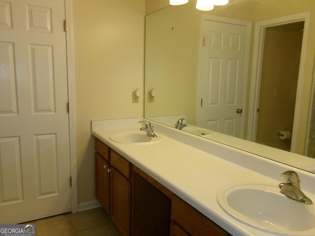 full bathroom with double vanity, tile patterned flooring, and a sink