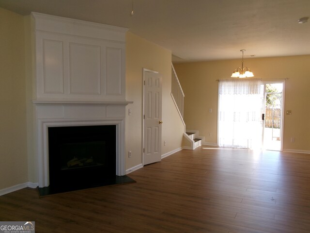 unfurnished living room with stairs, baseboards, a fireplace, and dark wood-type flooring