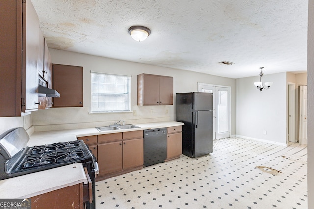 kitchen with light countertops, visible vents, a sink, under cabinet range hood, and black appliances