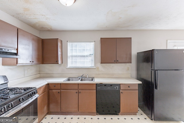 kitchen featuring light floors, under cabinet range hood, light countertops, black appliances, and a sink