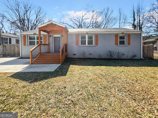 view of front of property with stucco siding, a shingled roof, a front yard, crawl space, and fence