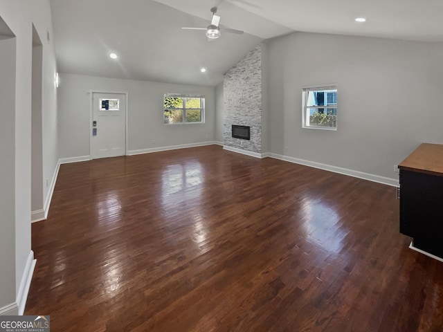 unfurnished living room featuring baseboards, a ceiling fan, lofted ceiling, dark wood-style flooring, and a fireplace