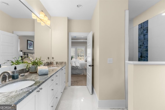 ensuite bathroom with double vanity, tile patterned floors, a sink, and ensuite bathroom