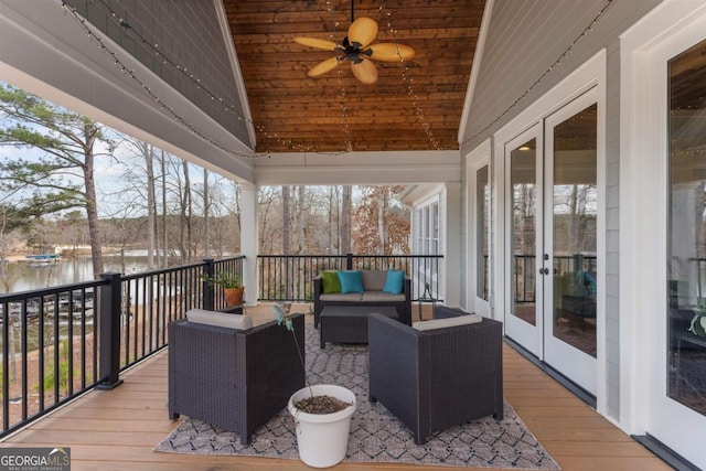 sunroom with a ceiling fan, lofted ceiling, french doors, and a water view