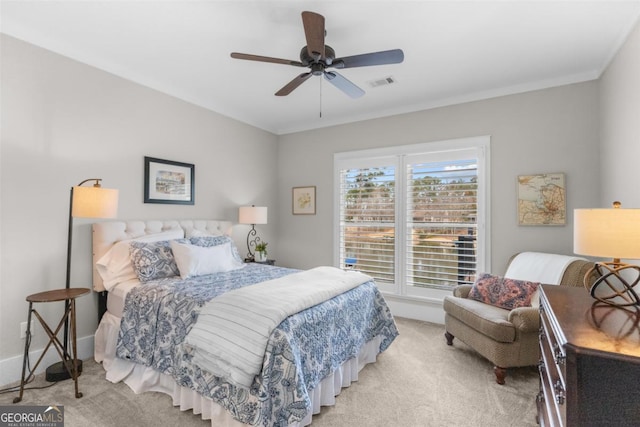 carpeted bedroom with baseboards, ornamental molding, visible vents, and a ceiling fan