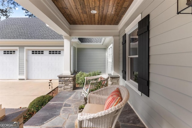 exterior space featuring driveway, an attached garage, and a porch