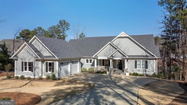 craftsman-style home with driveway, a porch, a chimney, and an attached garage