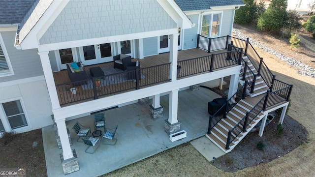 back of house featuring a shingled roof, a patio, a deck, and stairs