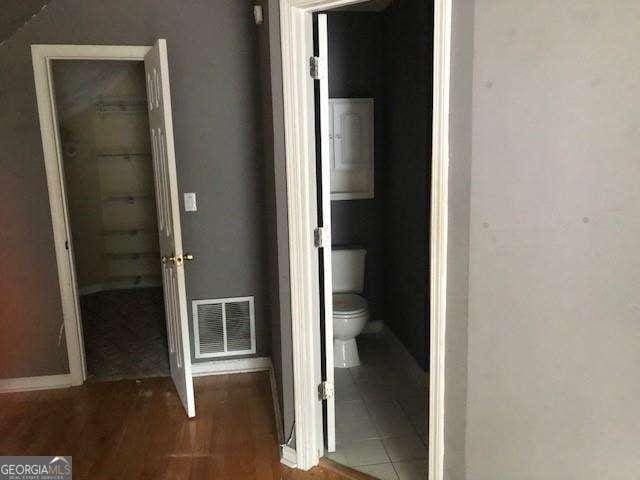 hallway with visible vents and wood finished floors