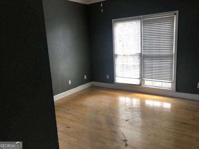 empty room featuring baseboards and wood finished floors