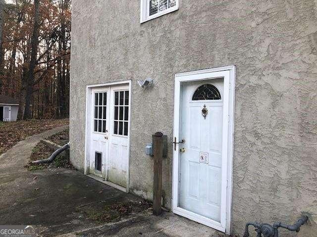 doorway to property featuring stucco siding