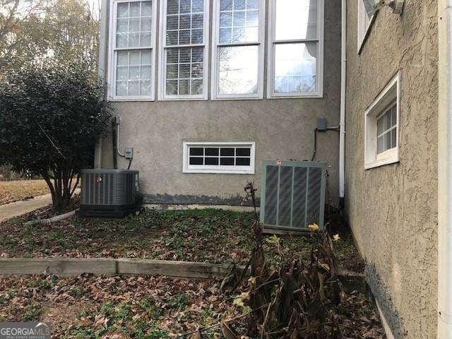 view of side of home featuring stucco siding and central AC unit