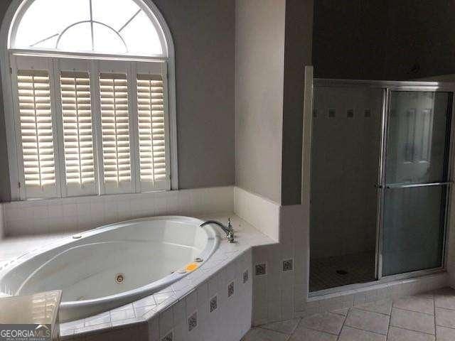 full bath featuring a tub with jets, a shower stall, and tile patterned floors