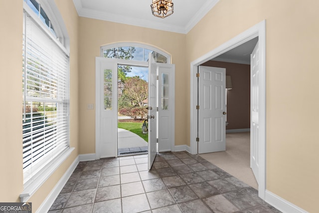 foyer with baseboards and crown molding