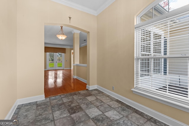 entryway with ornamental molding, arched walkways, french doors, and baseboards