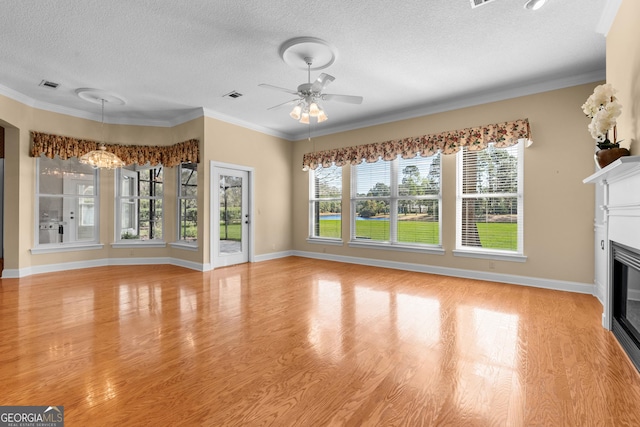 unfurnished living room featuring light wood finished floors, visible vents, a glass covered fireplace, baseboards, and ceiling fan with notable chandelier