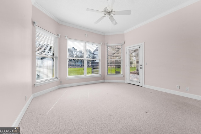 unfurnished room with ornamental molding, carpet flooring, a ceiling fan, and baseboards