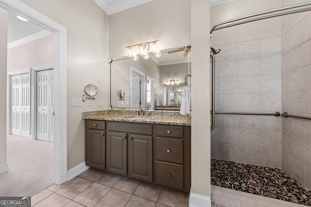 bathroom with ceiling fan, ornamental molding, tiled shower, and vanity