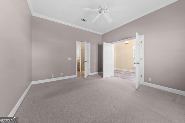 unfurnished bedroom featuring light colored carpet, visible vents, crown molding, and baseboards