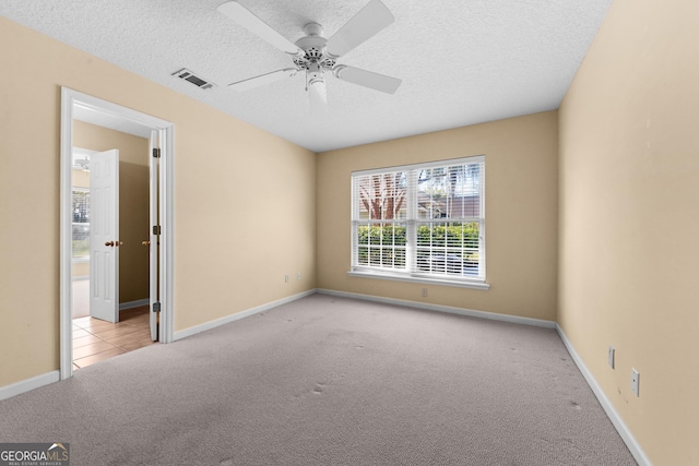 unfurnished bedroom with baseboards, a textured ceiling, visible vents, and carpet flooring