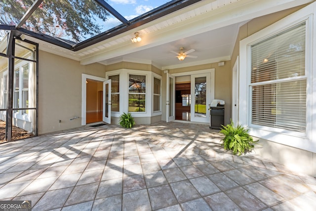 view of patio featuring ceiling fan, glass enclosure, and area for grilling