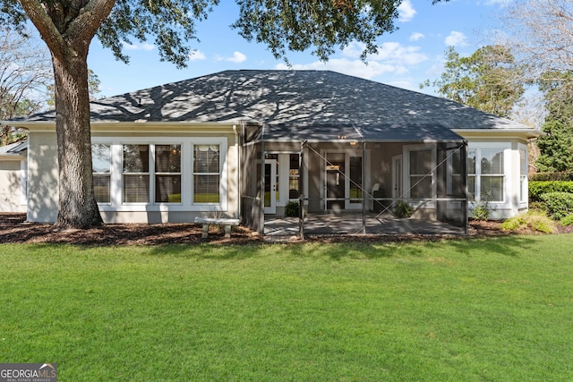 back of property featuring a shingled roof, a yard, and a patio