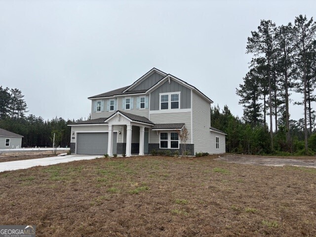 203 Park View Ln, Kingsland, GA 31548 - craftsman inspired home with board and batten siding, driveway, an attached garage, a front lawn, and central AC unit