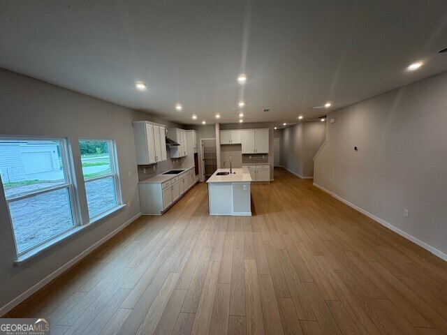203 Park View Ln, Kingsland, GA 31548 - kitchen with baseboards, black electric stovetop, light wood-type flooring, a kitchen island with sink, and recessed lighting