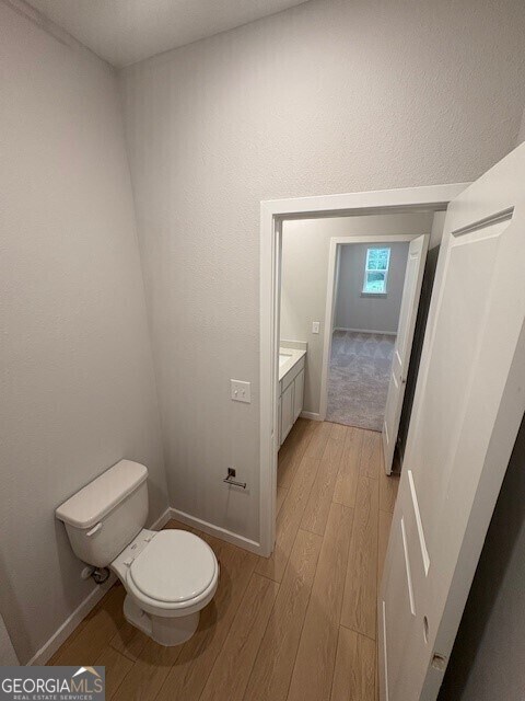 203 Park View Ln, Kingsland, GA 31548 - bathroom with wood finished floors, baseboards, toilet, and vanity