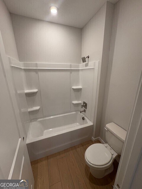203 Park View Ln, Kingsland, GA 31548 - bathroom featuring wood finished floors, toilet, and shower / washtub combination